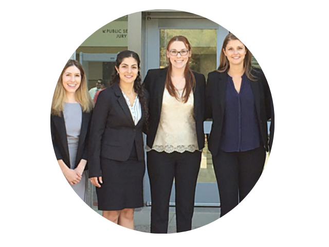 Group of law students in business clothes stand together for a smiling photo